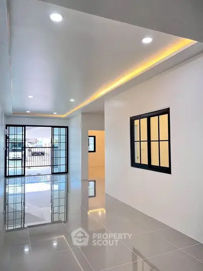 Spacious modern living room with glossy tiled floors and large windows for natural light.