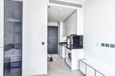 Modern minimalist kitchen with sleek cabinetry and built-in appliances in a bright apartment.