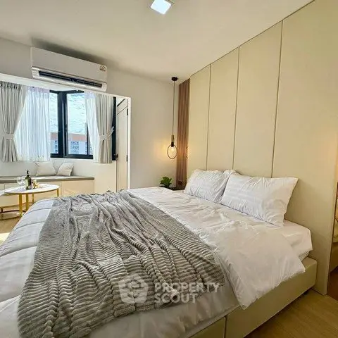 Modern bedroom with cozy decor and natural light, featuring a large bed and stylish furnishings.