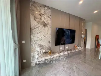Luxurious modern living room with marble accents and large flat-screen TV, perfect for entertainment.