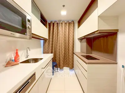Modern kitchen with sleek cabinetry and built-in appliances in a compact layout.