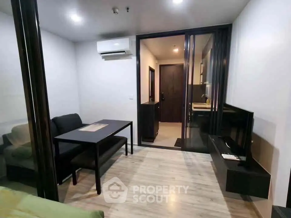 Modern living room with sleek furniture and open kitchen layout in a stylish apartment.