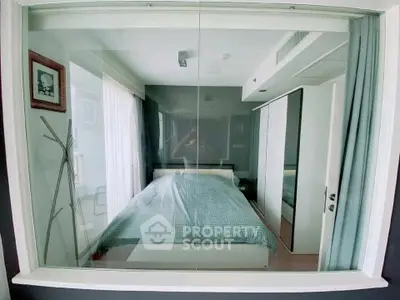 Modern bedroom with large window and stylish decor in a contemporary apartment.