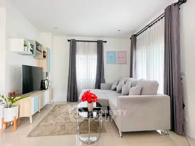 Modern living room with stylish decor, large windows, and cozy sectional sofa.