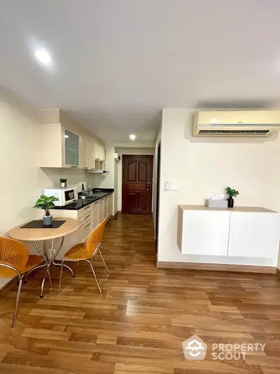 Modern kitchen and dining area with wooden flooring and air conditioning