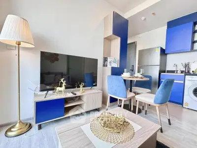 Modern living room with stylish blue accents and open kitchen layout