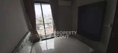 Cozy bedroom with city view and large window, perfect for urban living.