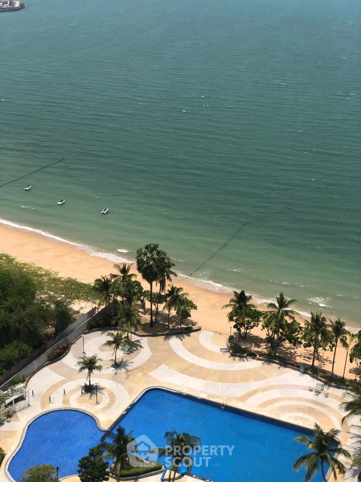 Stunning beachfront view with pool and palm trees, perfect for luxury living.