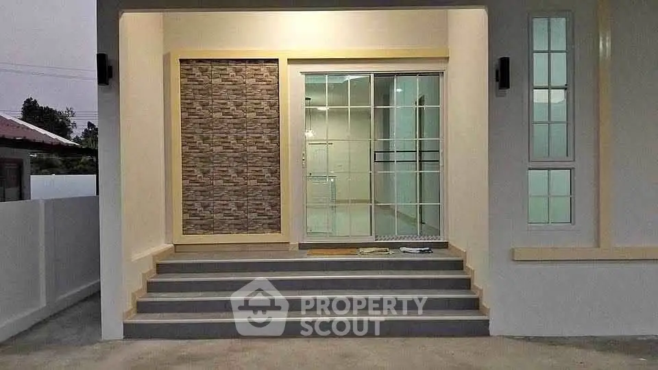 Modern house entrance with stylish stone accent wall and glass door