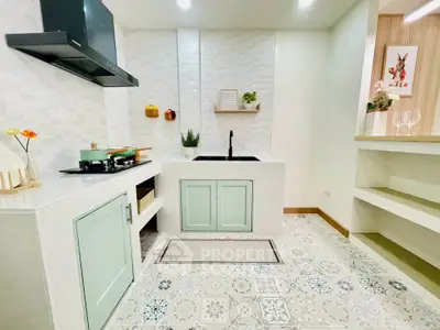 Charming kitchen with pastel cabinets and patterned tile flooring, featuring a modern gas stove and sleek design.