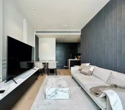 Modern living room with sleek design, featuring a marble coffee table and open kitchen layout.