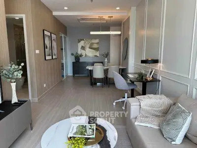 Modern living room with elegant decor and dining area, featuring stylish furniture and wall art.