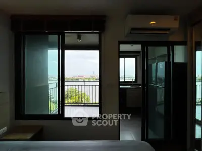Modern bedroom with balcony and river view, featuring sleek design and natural light.