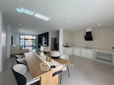 Spacious open-plan living and dining area with modern kitchen in a stylish home.