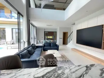 Luxurious modern living room with high ceilings, large windows, and elegant marble accents.