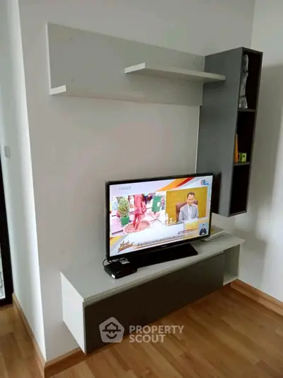Modern living room with sleek TV unit and wooden flooring, perfect for cozy entertainment.