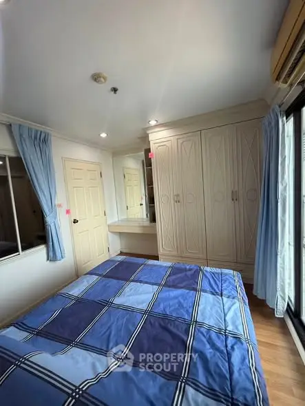 Cozy bedroom with built-in wardrobe and blue plaid bedding