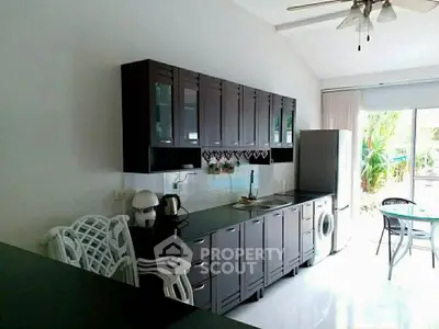 Spacious kitchen with modern appliances and garden view, perfect for culinary enthusiasts.