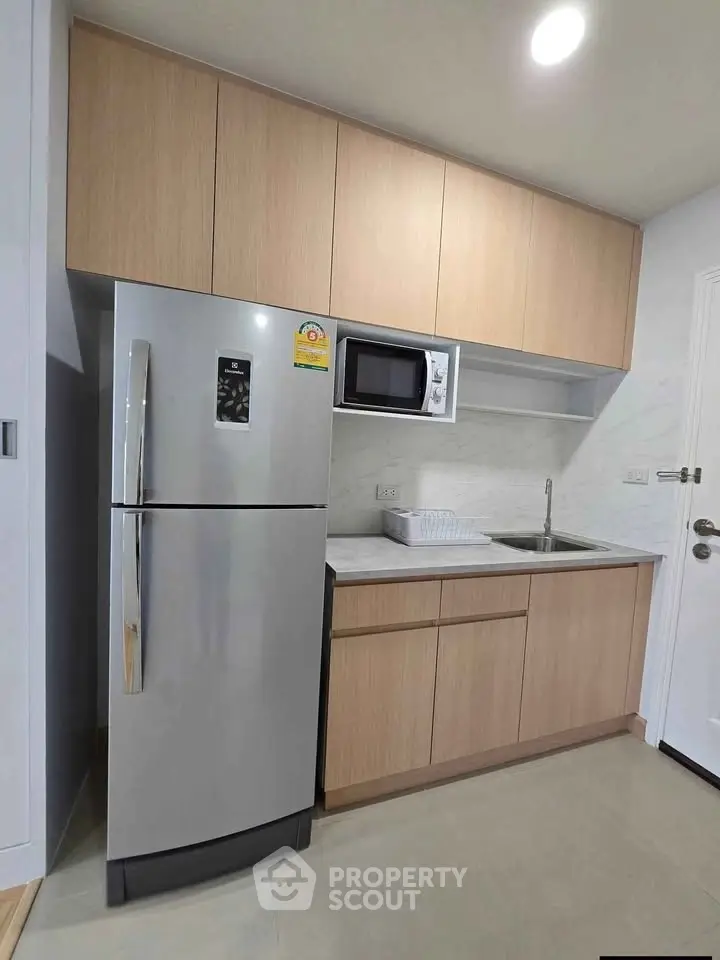 Modern kitchen with sleek cabinetry and stainless steel appliances in a compact layout.