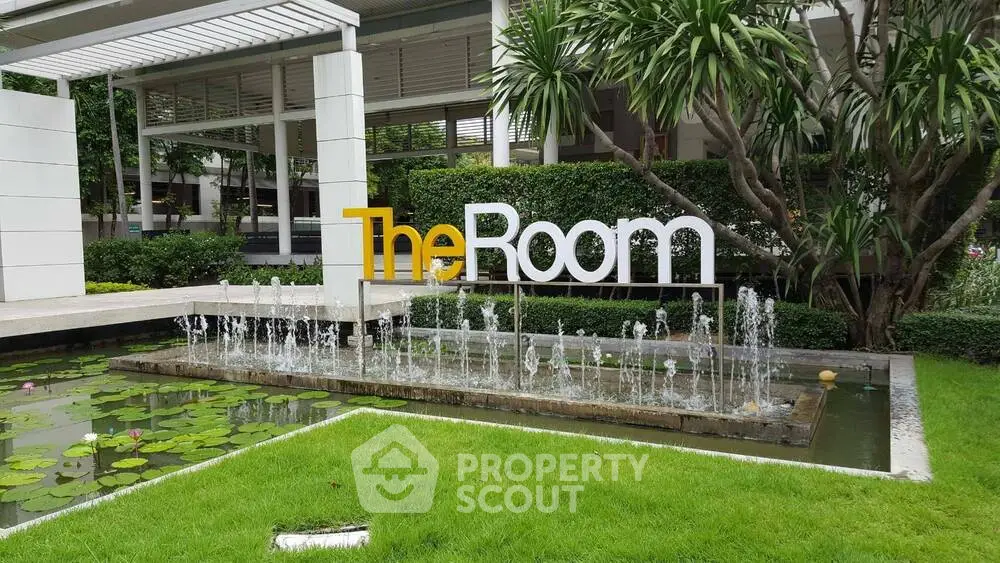 Modern garden entrance with water feature and stylish signage in luxury real estate property.