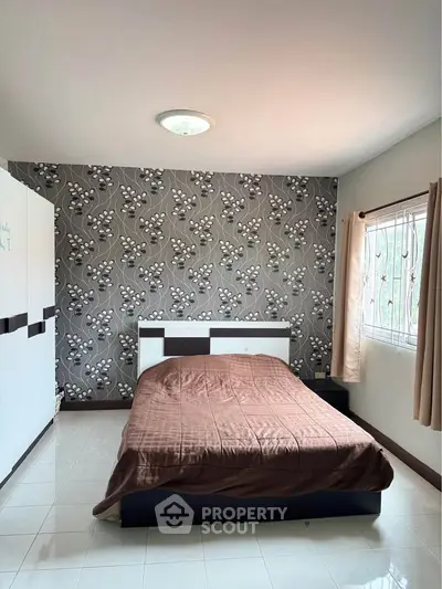 Cozy bedroom with stylish wallpaper and natural light