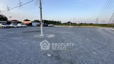 Spacious gravel parking lot with multiple cars and open sky view