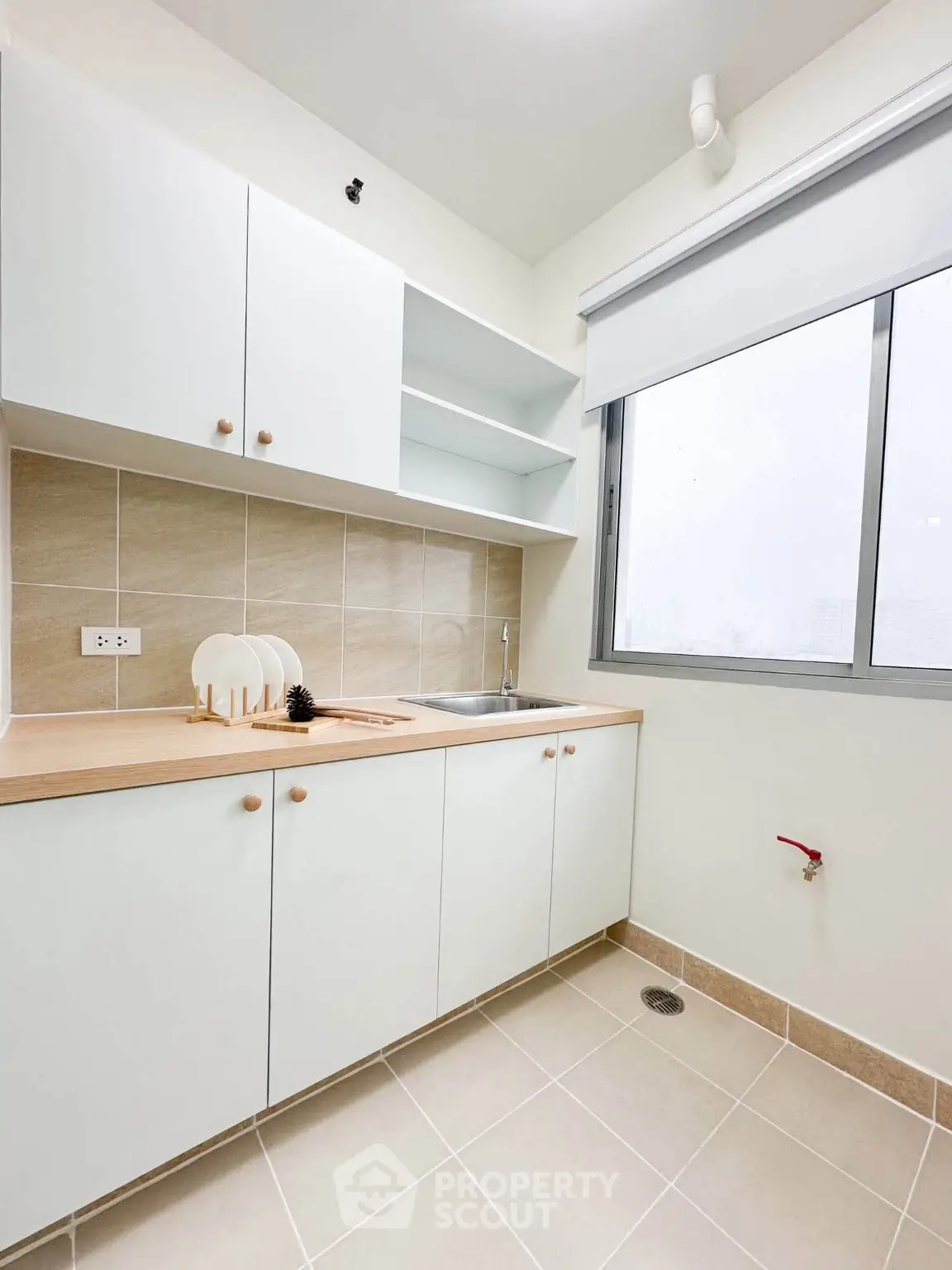 Modern kitchen with sleek cabinetry and large window for natural light