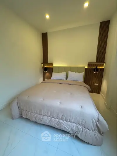 Modern bedroom with cozy bed and stylish lighting in a contemporary apartment.