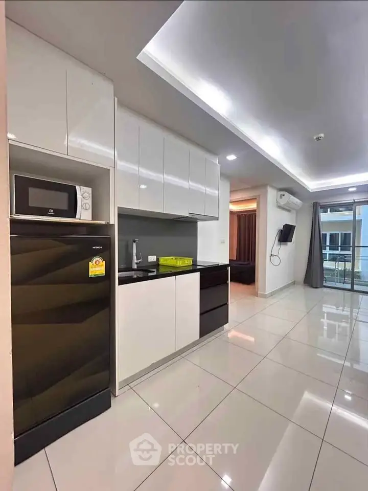 Modern kitchen with sleek cabinets and appliances in a stylish open layout apartment.