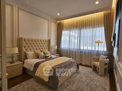 Luxurious bedroom with elegant decor, plush bed, and large window with sheer curtains.