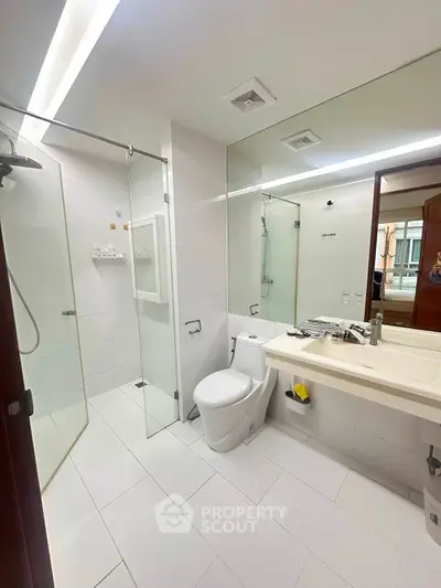 Modern bathroom with glass shower and sleek fixtures in a contemporary home.