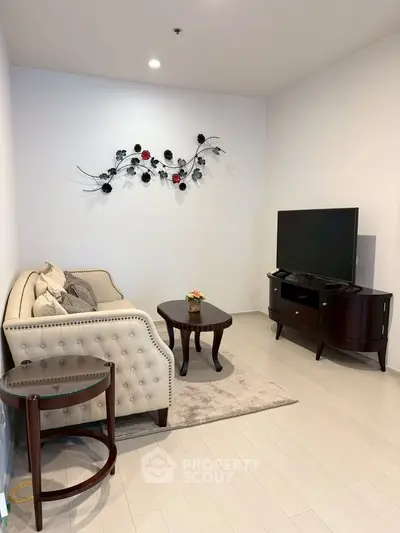 Elegant living room with plush sofa, modern TV stand, and stylish wall decor in a cozy setting.