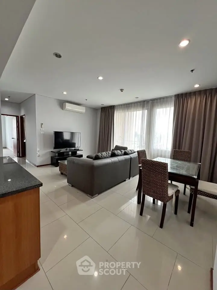 Spacious modern living room with sleek furniture and large windows in a stylish apartment.