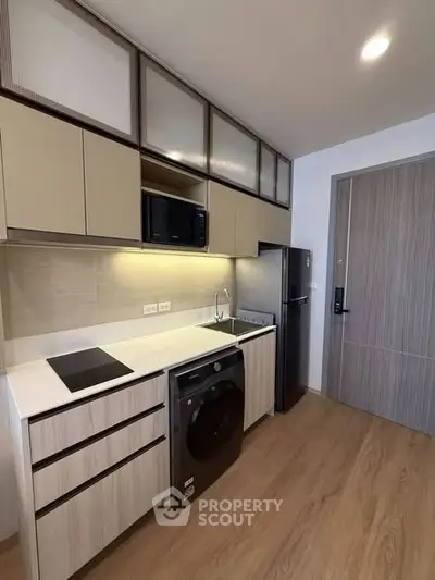 Modern kitchen with sleek cabinetry and appliances in a compact layout.