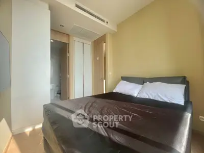 Modern bedroom with sleek design and ample natural light, featuring a comfortable bed and stylish decor.
