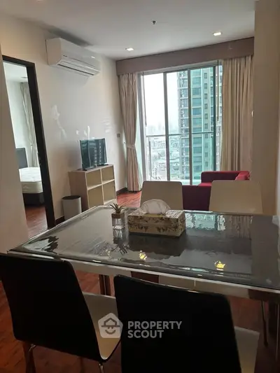 Modern apartment with open living and dining area, featuring large windows and city view.