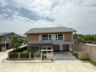 Modern two-story house with spacious driveway and lush greenery