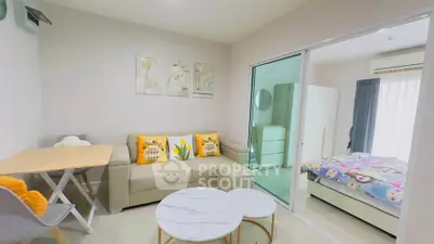 Modern living room with cozy sofa and sliding glass door to bedroom
