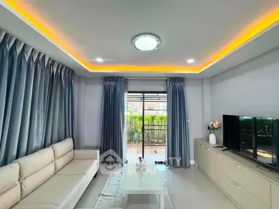 Modern living room with elegant lighting and garden view, featuring a cozy sofa and sleek TV unit.