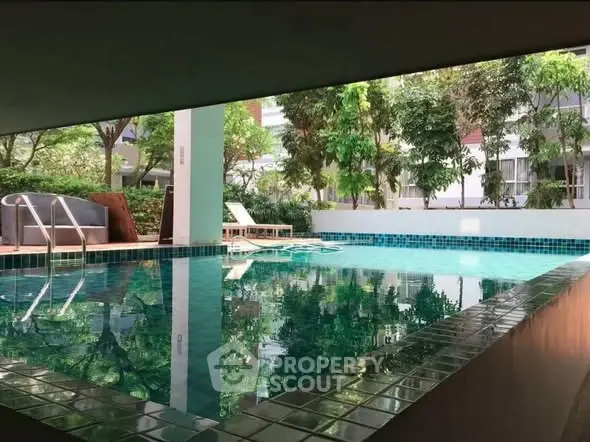 Luxurious residential pool area with lush greenery and modern design.