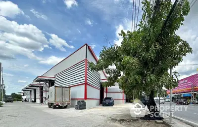 Spacious industrial warehouse with ample parking and modern design on a sunny day.