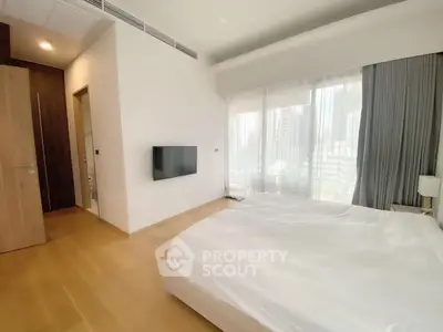 Spacious modern bedroom with large window and city view, featuring minimalist decor and wall-mounted TV.