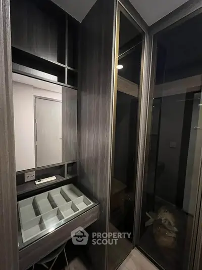 Modern walk-in closet with sleek dark wood finish and ample storage space.