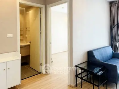 Modern apartment interior with cozy living room and adjacent bathroom, featuring stylish furniture and neutral tones.