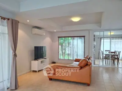 Spacious living room with modern leather sofa and large windows offering natural light.