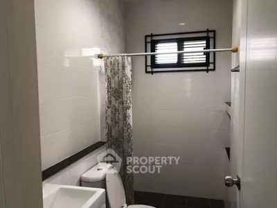 Modern bathroom with sleek white tiles and floral shower curtain