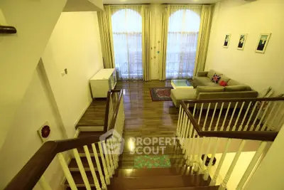 Spacious living room with elegant staircase and cozy seating area