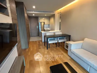 Modern open-plan living room with wooden flooring and sleek kitchen design