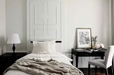 Elegant bedroom with stylish decor and cozy ambiance, featuring a single bed and modern furnishings.