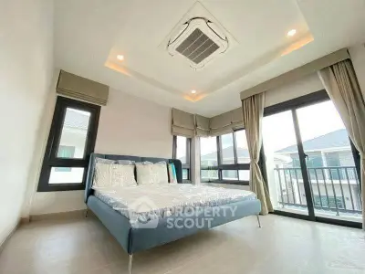 Spacious bedroom with large windows and modern decor in a luxury home.